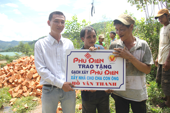 Anh Trần Khắc Nguyên đại diện công ty Phú Điền trao tặng gạch cho anh em ông Hồ Văn Lang